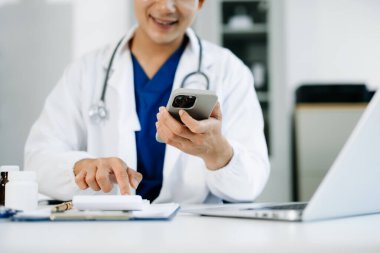 Sağlık masrafları ve ücretleri kavramı. Akıllı doktor el sabah ışık Hastanesi'nde sağlık giderleri için bir hesap makinesi ve akıllı telefon, tablet kullanılan