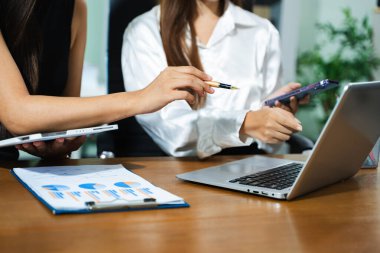 İş ekibi toplantısı sunar. Finans müdürleriyle çalışan profesyonel yatırımcı. Bilgisayarlı akıllı telefon ve dijital tablet ile sabah ışığı altında çalışır.