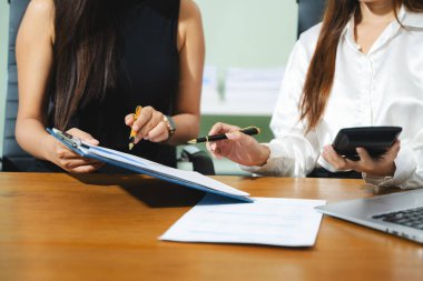 Sosyal ağ diyagramlı dizüstü bilgisayar ve tablet kullanan iş adamı ve masadaki verileri kavram olarak tartışan iki meslektaşı