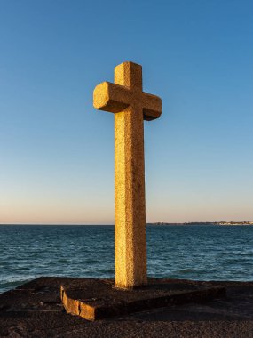 Hristiyan taşı Saint-Malo, Brittany, Fransa 'da deniz kenarından geçiyor. Gün batımının ılık ışığı, açık deniz ufku ve açık gökyüzü..
