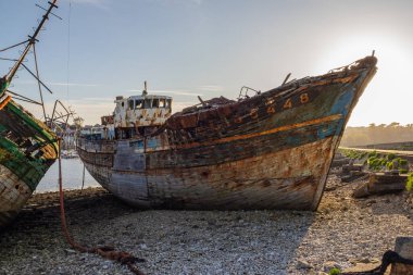 Camaret-sur-Mer gemi enkazı mezarlığı, Finistere, Brittany, Fransa 'nın çakıllı sahilinde karaya oturmuş çürüyen bir balıkçı teknesinin yakın görüntüsü..
