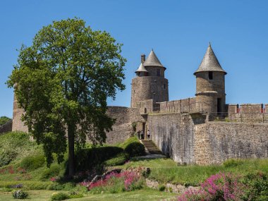 Fougeres Şatosu 'nun Gobelins kulesi, sağında Guib kulesi ve ön taraftaki ikinci muhafazanın savunma duvarları bulunan üçüncü muhafaza kapısının arkasında duruyor..