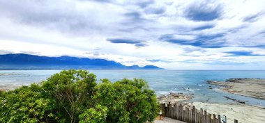 Kaikoura, Yeni Zelanda - 24 Ocak 2025: Okyanus manzaralı manzaralı, arka planda dağlar ve bulutlu bir gökyüzü.