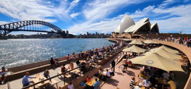 Sydney Opera Salonu, Avustralya - 3 Nisan 2022 Sydney Limanı 'nın nefes kesici manzarası, görkemli Liman Köprüsü' nün yanındaki Opera Binaları 'nın beyaz yelkenlileri sergileniyor..