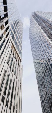 Londra, Birleşik Krallık - 13 Ağustos 2023: Gökdelenler Bulutlu Gökyüzüne Karşı. Çoklu gökdelenlerin hayranlık uyandıran perspektifi, gösterişli, cam kaplı cepheleriyle izleyicinin üzerinde yükseliyor..