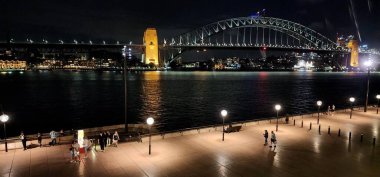 Sydney Harbour, Avustralya - 12 Ocak 2025: Sydney Harbour Bridge at Night. Karanlık gökyüzüne karşı güzelce aydınlatılmış Sydneys ikonik Liman Köprüsü 'nün büyüleyici gece manzarası.. 