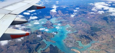 Christchurch, Yeni Zelanda - 30 Ocak 2025: Air Sunset View from Airplane Window. Gökyüzü turuncu, kırmızı ve mor renkli canlı tonlarla boyanır. Ufuk boyunca büyüleyici bir parıltı yayar.. 