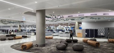 Auckland Havaalanı, Yeni Zelanda-18 Şubat 2025: Sanatsal Tavan Kurulumu ile Modern Havalimanı Güvenlik Kontrol Noktası. Çoklu güvenlik şeritlerinin bulunduğu çağdaş bir havaalanı güvenlik kontrol noktası..
