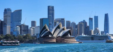 Sydney Harbour, Avustralya - 22 Ekim 2023: Sydney Opera Binası ve Liman Trafiği ile City Skyline. Ön plandaki ikonik Sydney Opera Binası, kendine özgü yelken benzeri mimarisi var.. 