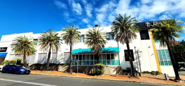 Maroubra, Sydney, Avustralya -14 Ekim 2023: The Juniors Maroubra Club with Palm Trees and Street View. Deniz mavisi tenteleri ve pencere panjurlarıyla özgün beyaz bir yüzü olan tanınmış bir kulüp.