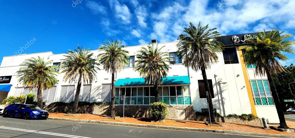 Maroubra, Sydney, Australia -14 October 2023: The Juniors Maroubra Club with Palm Trees and Street View. A well-known club with a distinctive white facade accented by teal awnings and window shutters