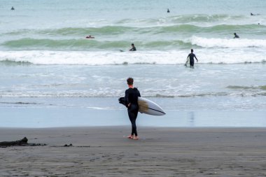 Muriwai Sümsük Kuşları Sahili 'nde sörfçü - Yeni Zelanda