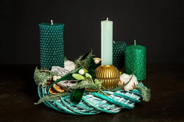 Symbolic Advent wreath with 4 candles Decorative wreath of four green Advent candles in an Advent wreath decoration on a dark background. Tradition before Christmas. Festive still life.