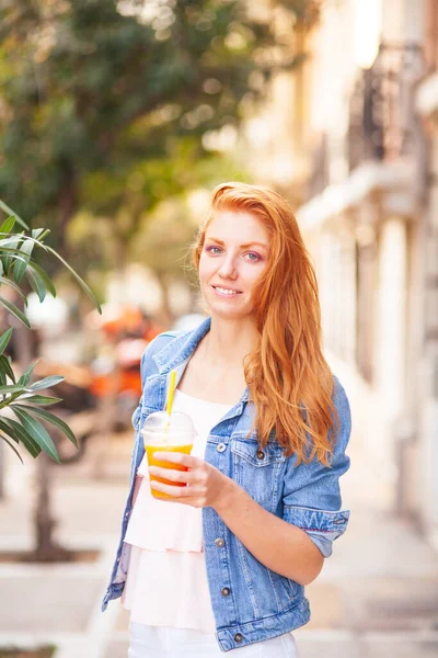 오렌지 주스를 곁들인 아름다운 아가씨 거리에서 — 스톡 사진