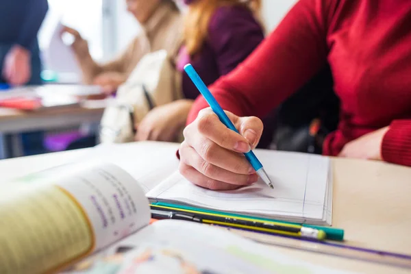 Sınıfta ders çalışan bir grup öğrencinin yakın çekimi.