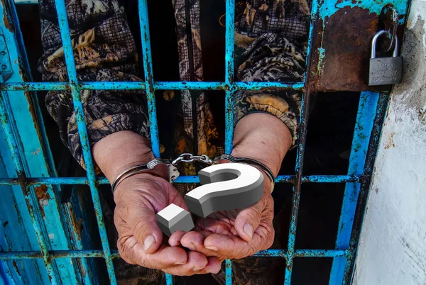 Hapishane Parmaklıklarında Kelepçeli Soru Işareti Olan Bir Avuç Içi — Stok fotoğraf