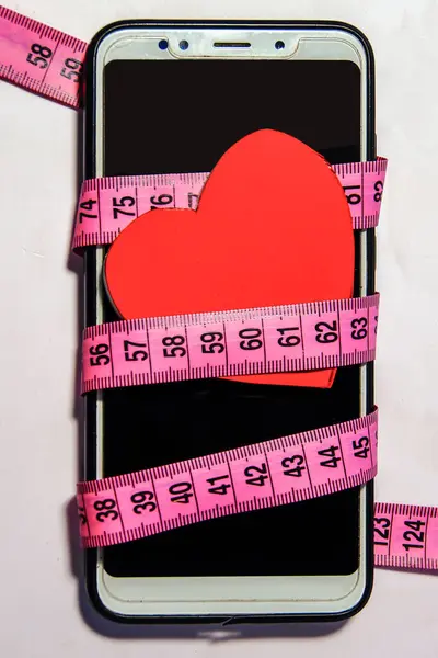 Ölçüm Bandı Insan Kalbi Modeliyle Sarılı Bir Cep Telefonu Sevgiyi — Stok fotoğraf