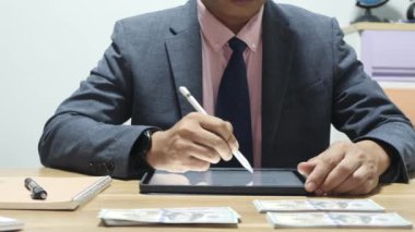 Banka veznedarı çalışıyor ve 100 dolar sayıyor.
