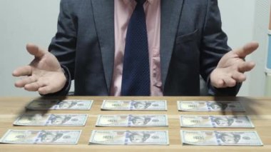 Banka veznedarı çalışıyor ve 100 dolar sayıyor.