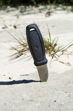 Av bıçağı bir siyah Plastik Saplı kuma sıkıştı