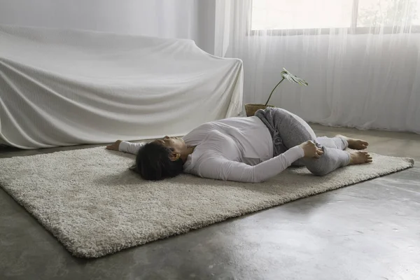 stock image Old lady laydown on floor and twist her body,posing yoga for exercise at living room.