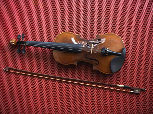 Violin and bow put on background,show detail of acoustic instrument.