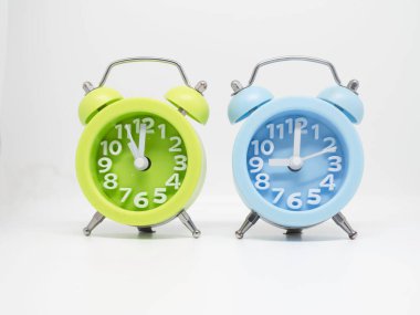 Blue and Green color Alarmclock put together on white background,show time on clockface.