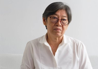 Yüzünde kırışıklıklar olan yaşlı bir kadının portresi, gözlük takıyor, üzgün gözlerle bakıyor, zihinsel ve yalnız hissediyordu.