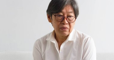 Yüzünde kırışıklıklar olan yaşlı bir kadının portresi üzgün ve mutsuz duygularla bakıyor.