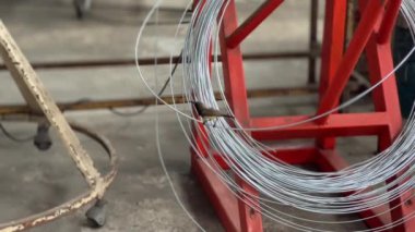 Fabrikada tel üzerine tünemiş küçük kuş, kentsel hayvan yaşam kümes hayvanları.