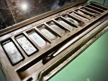 Kullanılmış göz farı kutusu, dağınık renk paleti ve kirli, bulanık ışık. Lens ışığı efekti..