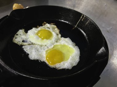 Yumurtayı dökme demir tavada kızart, geleneksel ev yapımı yemek pişirme tarzında..