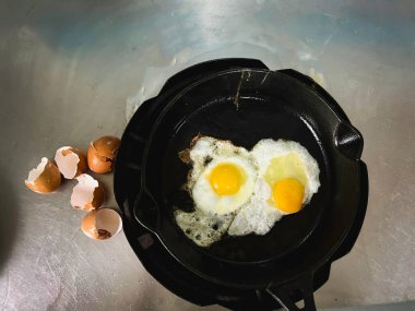 Yumurtaları dökme demir tavada, yumurta kabuğunun yanında, geleneksel ev yapımı pişirme tarzında kızart..