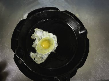 Yumurtayı siyah tavada kızart, geleneksel ev yapımı yemek pişirme tarzında..