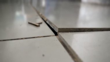 Seramik fayanslar birbirlerinden ayrılıp, parçalarına ayrılıp, parçalarına ayrıldıklarını, hasar gördüklerini ve yüzey zeminini keşfettiklerini gösteriyor. Nem ve sıcaklık değişikliklerinden kaynaklanan problem.