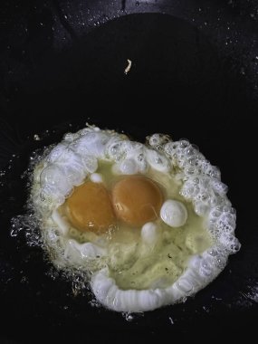 Siyah tavada kızarmış yumurta, yemek için ev yapımı yemek..