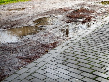 Yağmur fırtınasından sonra yoldaki çukurda su birikintisi. Risk ve güvensizlik kavramı