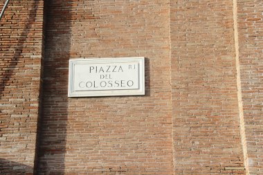 Roma, İtalya - 14 Eylül 2022: Piazza del Colosseo Caddesi veya Squere İsim Levhası ve Tuğla Duvar Roma, İtalya