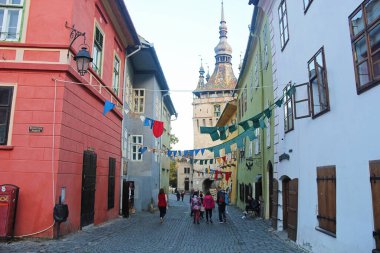 Sighisoara, Romanya - 27 Eylül 2019: Saat Kulesi ile Sighisoara Eski Kent Caddesi. Romanya 'daki Transilvanya Manzarası.