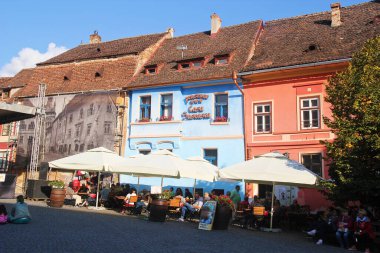 Sighisoara, Romanya - 27 Eylül 2019: Romanya 'nın Sighisoara kentindeki Cobblestone Caddesi, Transilvanya, Restoran Teraslı