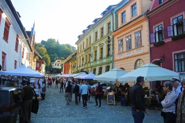 Sighisoara, Romanya - 27 Eylül 2019: Transilvanya, Romanya 'daki Sighisoara kaldırım taşı sokağı Restoran Terasları ve Market