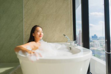 Güzel bir Asyalı kadın portresi. Banyo içinde küvet dekorasyonunda rahatlama ve rahatlama.