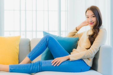 Güzel bir Asyalı kadın portresi. Rahat ol. Oturma odasının iç kısmındaki kanepede keyfine bak.