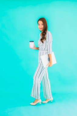 Güzel bir Asyalı kadın portresi mavi izole edilmiş bilgisayar bilgisayarı kullanıyor.