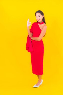 Güzel bir Asyalı kadın portresi. Sarı izole edilmiş arka planda hareketli gülümsüyor.