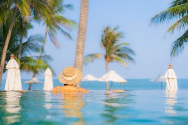 Güzel bir Asyalı kadın portresi. Rahatlayın. Yüzme havuzunun, deniz kenarındaki okyanus manzarasının keyfini çıkarın.