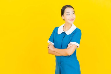 Güzel bir Asyalı kadın portresi ve sarı arka planda hareketli bir gülümseme.