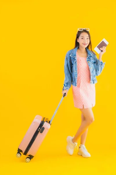亚洲年轻貌美的女子 头戴旅行袋 头戴护照 背景为黄隔离的登机牌 — 图库照片