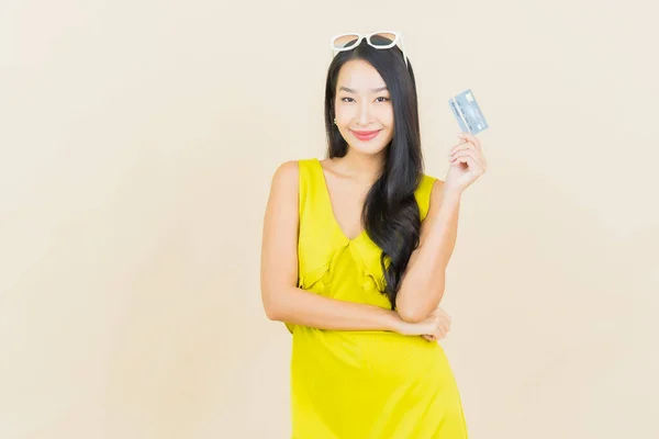 ポートレート美しいです若いですアジアの女性笑顔でクレジットカードで色の背景 — ストック写真