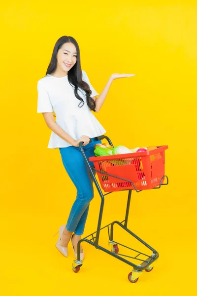 아름다운 아시아 노란색 배경으로 슈퍼마켓의 식료품 바구니와 — 스톡 사진